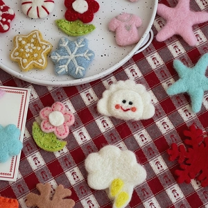 Macro detail of colorful wool felt DIY accessories including flowers, stars, and snowflakes