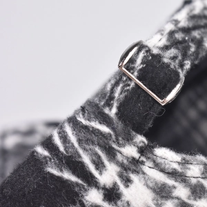 Macro detail of plaid wool baseball cap showing thick fiber texture and metal buckle