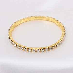 Detail of a gold-plated tennis bracelet featuring a single row of sparkling zircon stones