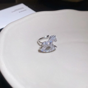 Close-up of silver rocking horse ring with pavé zircons on a white ceramic tray