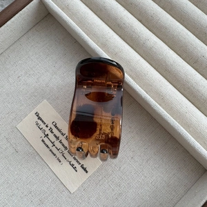Macro detail of amber tortoiseshell claw clip showing resin texture and spring