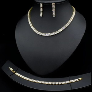 Macro shot of gold-plated jewelry set featuring emerald-cut cubic zirconia crystals