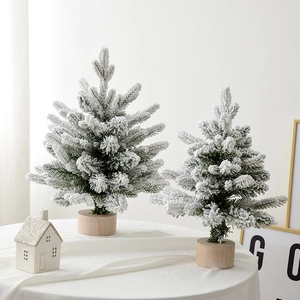 Mini flocked Christmas trees with snow effect and wooden bases for festive tabletop decor