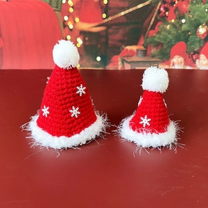 Close-up of knit Christmas hats for pets with snowflake sequins and plush pom-poms