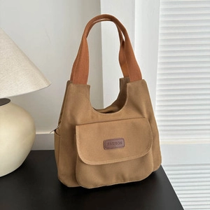 Primo piano della borsa in tela marrone con trama premium ed etichetta in pelle fashion