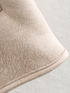Detailed close-up of beige suede fabric texture with warm fleece lining for winter coats