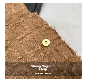 Detail view of the strong magnetic buckle on textured brown fabric with fringe edges