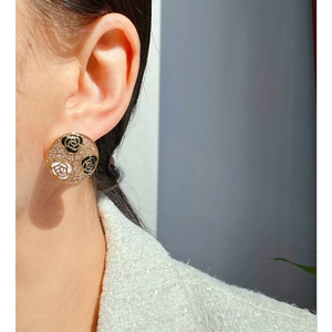 Elegant gold round earrings with black and white camellia flowers and pavé crystals