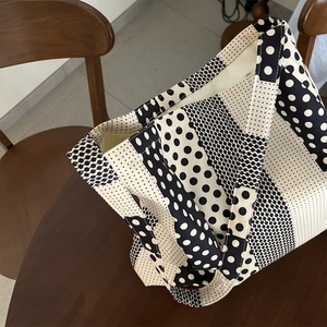 Vista dettagliata della borsa tote in tela con moderno motivo a pois bianchi e neri