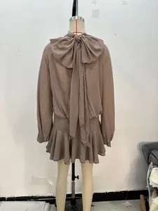 Detalle de un minivestido de gasa con lazo decorativo grande en la espalda y volante
