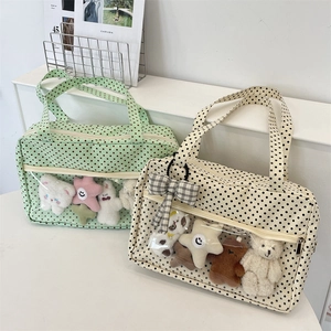 Close-up of canvas tote bag with polka dots and transparent PVC pocket for plush toys