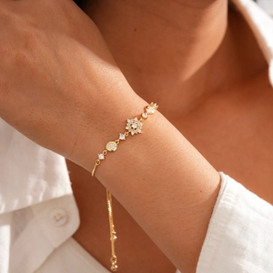 Detail of adjustable gold snowflake bracelet with sparkling zircons on a model wrist