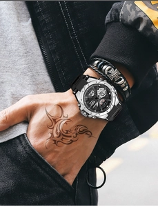 Close-up of a men's sports watch with a silver metal case and a black silicone strap