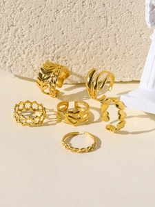 Macro detail of a set of six gold-plated rings with wheat and heart textured patterns
