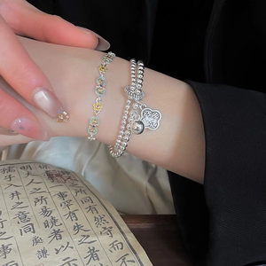 Detail of Chinese style enamel flower bracelet and silver bead charm set on hand