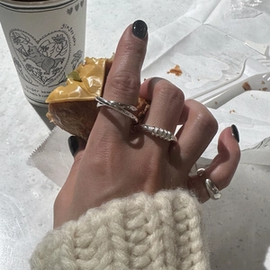 Minimalist 925 sterling silver twisted rope ring set worn in a cozy cafe setting