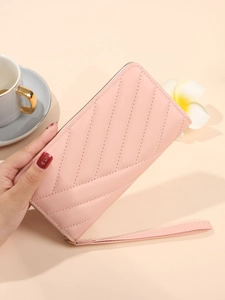 Pink quilted long wallet for women with zipper closure and wristlet strap handheld view