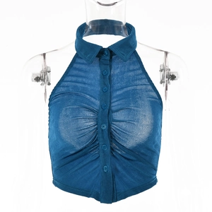 Dettaglio del top blu con scollo all'americana, trama pieghettata e bottoni frontali