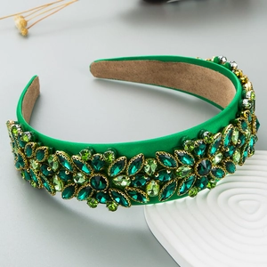 Détail d'un serre-tête baroque vert émeraude avec des motifs de fleurs en strass complexes