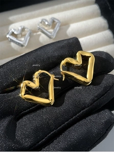 Detailed close-up of golden 3D heart-shaped earrings with unique crinkle texture