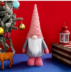 Detailed view of pink Christmas gnome plush with tall hat and white fiber beard on festive background