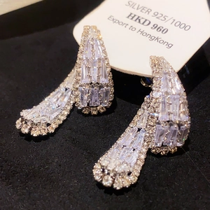 Macro shot of luxury sterling silver teardrop earrings with sparkling baguette zirconias