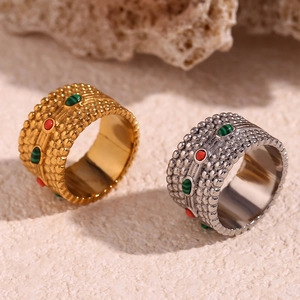 Macro detail of 18K gold and silver rings featuring colorful natural stones and dotted texture