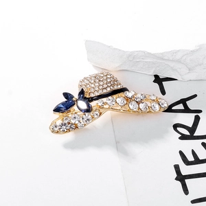 Macro view of gold-plated sun hat brooch with white rhinestones and blue crystal bow