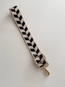 Adjustable beige and black herringbone weave bag strap with premium gold metal hardware