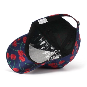 Detailed view of the navy baseball cap interior with cherry patterns and metal buckle