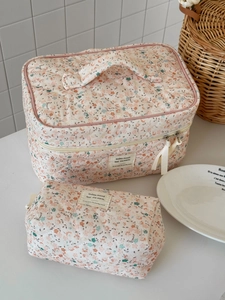 Dettaglio set pochette trucchi in velluto a coste floreale con fiocchi e manico superiore