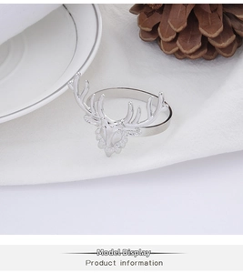 Detailed view of a silver elk napkin ring set on a festive Christmas table setting