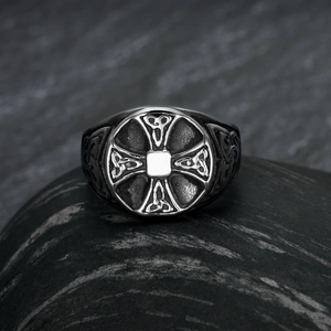 Macro shot of vintage Viking cross ring with Celtic knots on dark textured stone