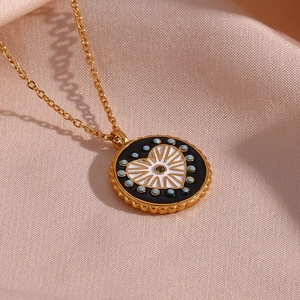 Collier médaille dorée avec pendentif cœur en émail noir et blanc sur soie beige