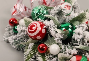 Macro view of Christmas ball ornaments with snowflake patterns and snow-flocked pine needles