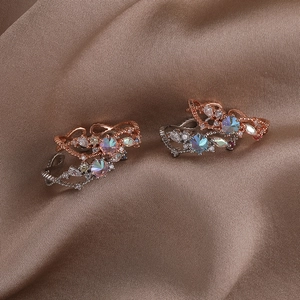 Detail of vine-shaped ear cuffs in rose gold and silver finish with colorful zircons