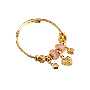 Golden charm bracelet with pink glass beads and heart pendants on white background