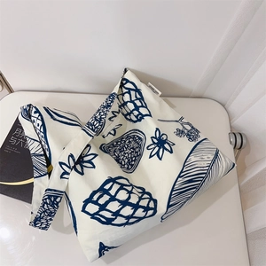 Détail du sac cabas en toile avec motifs floraux bleu marine et étiquette simple wish