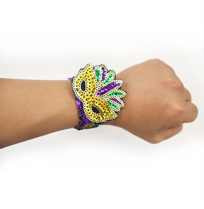 Detailed view of Mardi Gras sequin mask bracelet in vibrant gold, purple, and green on wrist