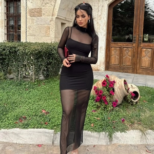 Détail de la robe maxi noire en mesh transparent avec manches longues et coupe ajustée