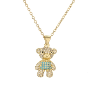 Detail of gold-plated bear pendant necklace with blue crystals and sparkling zircons
