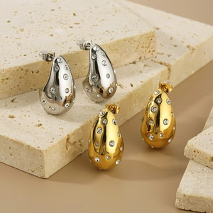Detailed view of teardrop earrings with pavé crystals in gold and silver finishes