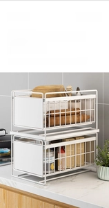 Detail of white 2-tier sliding under-sink storage rack with smooth pull-out carbon steel rails