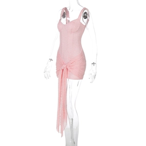Dettaglio dell'abito in pizzo rosa con design stringato frontale e cuciture in vita