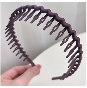 Detail of dark purple wavy headband showing non-slip plastic comb teeth for secure hair grip