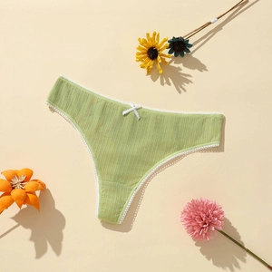 Close-up of light green ribbed fabric and white lace trim with a delicate bow detail