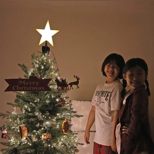 Rotating glowing star tree topper on a green artificial Christmas tree for home decor