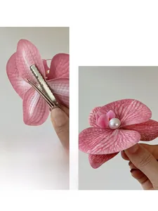 Close-up of pink orchid hair clip with realistic petal texture and center pearl detail