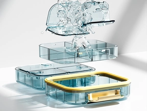 Exploded view of a blue-gray pill organizer showing waterproof seal and layered design