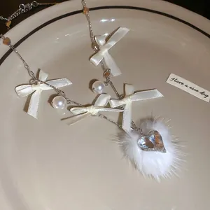 Elegant pearl necklace featuring white satin bow and heart crystal pompom pendant